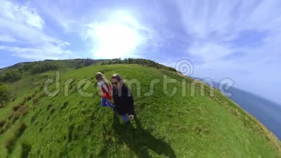 两个带360度摄像机的女孩沿着爱尔兰西海岸散步视频的预览图