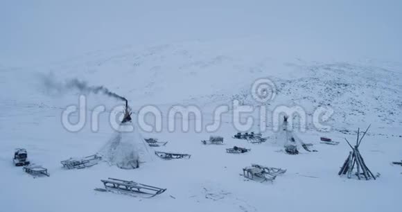 从山顶上用无人机捕捉到亚马尔的蒙古包营地蒙古包外有许多雪橇景色令人惊叹视频的预览图
