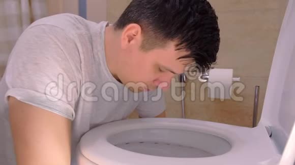 男人的肖像在坐在地板上的厕所里呕吐宿醉视频的预览图