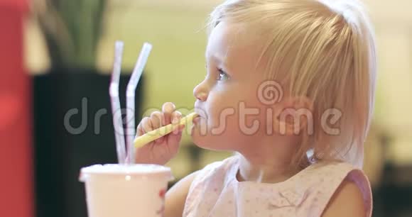 一个可爱的小女孩吃土豆薯条喝鸡尾酒视频的预览图