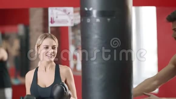 私人教练在体育俱乐部训练女子拳击视频的预览图