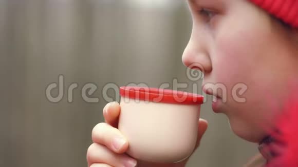 特写在春林中少年少女从保温瓶里喝茶旅行女郎用热水杯倒茶视频的预览图