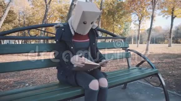 那个头上戴着包裹的女孩坐在长凳上看书穿夹克的女孩视频的预览图