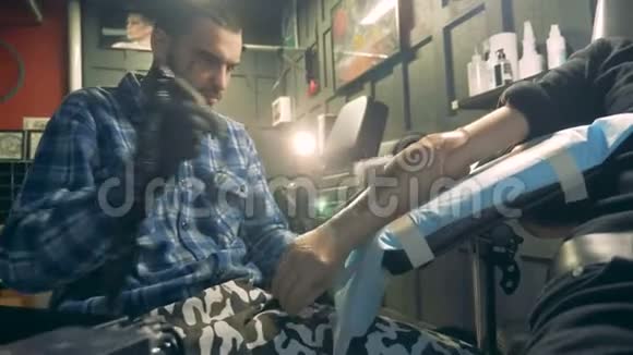 男艺术家正在纹身一只合成手并擦拭它视频的预览图