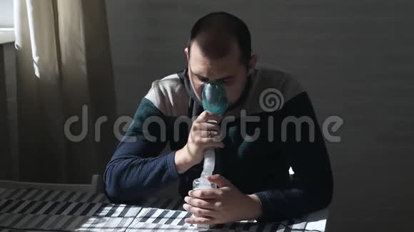 病人坐在沙发上用鼻吸器吸入把脸闭上使用雾化器和吸入器视频的预览图