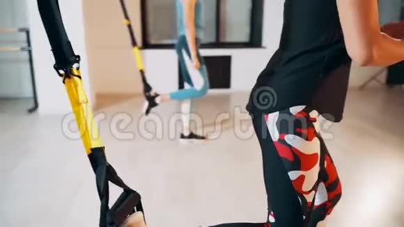 用悬吊的腿做支撑从事TRX循环的女孩视频的预览图