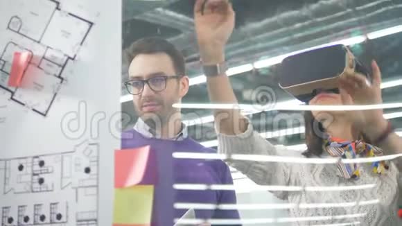 VR眼镜的女工程师和操作平板电脑的男工程师视频的预览图