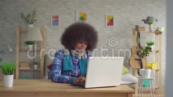 客厅坐在餐桌前的肖像非洲裔美国年轻女性发型非洲风格的围巾喉咙痛和视频的预览图