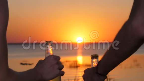 日落时分带着啤酒瓶在沙滩上散步视频的预览图