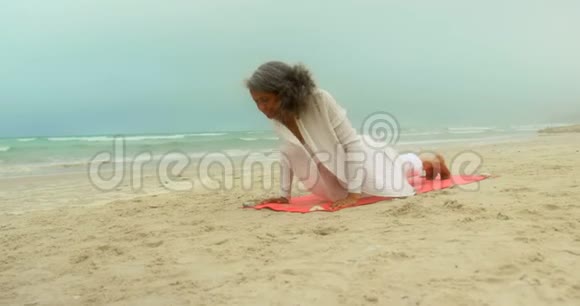 活跃的非洲裔美国老年妇女在海滩上练习瑜伽的正面景色视频的预览图