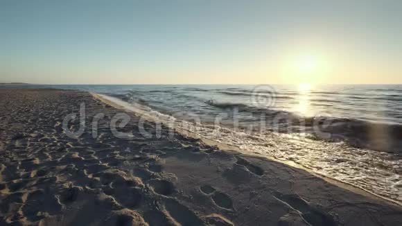 太阳在地平线上低垂波罗的海沙滩在柯罗尼亚的唾沫软波浪视频的预览图