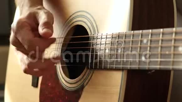 一位音乐家用手指从黄色吉他的弦上提取声音特写视频的预览图