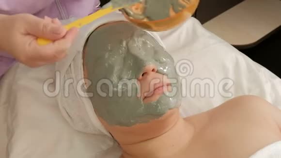 一位专业的美容师将海藻酸钠面膜敷在一位成年女性的脸上振兴程序视频的预览图