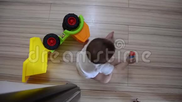 高角镜头可爱的七个月大的男孩在地板上玩教育玩具视频的预览图