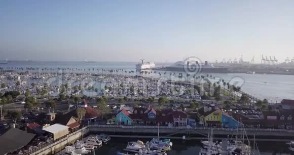 空中广角向前推进拍摄停泊在蓝水上的海岸线游艇视频的预览图