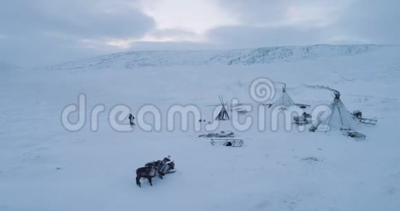 冬季在北极的鸟瞰大营蒙古包和跑步男子穿着传统的服装从毛皮视频的预览图