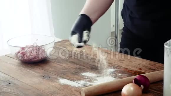 快餐厨师手戴手套在木板上滚出菲洛吐面面团切卷馅饼或蛋糕视频的预览图