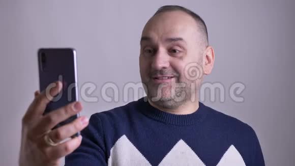 成年白种人男性的特写镜头视频中的白种人在愉快地交谈和微笑视频的预览图