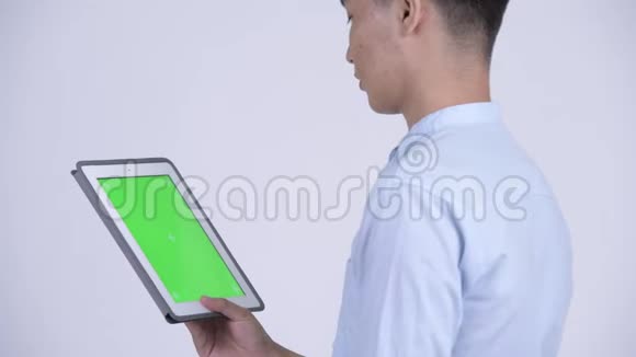 年轻快乐的亚洲商人使用数码平板电脑的近距离后视镜视频的预览图