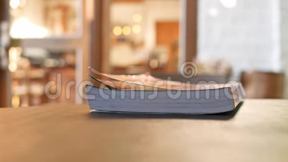 一本书放在咖啡馆的木桌上视频的预览图