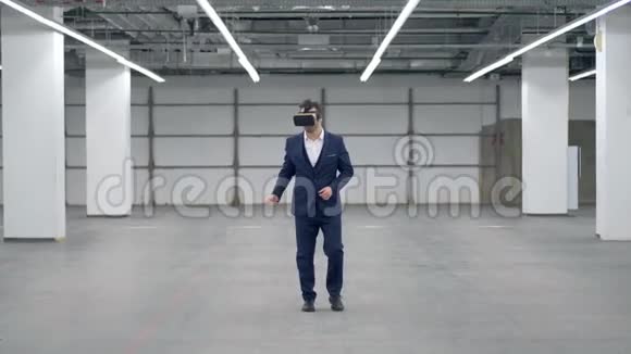 戴着虚拟现实眼镜的商人在一个空荡荡的大厅里走来走去视频的预览图