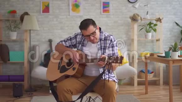 带眼镜的年轻音乐家不会弹吉他视频的预览图