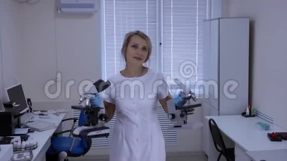 快乐女实验室技师手里拿着显微镜在实验室里跳舞视频的预览图