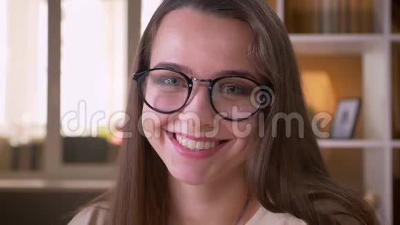 年轻貌美的白种人女学生戴着眼镜看着镜头笑着开心地笑着视频的预览图