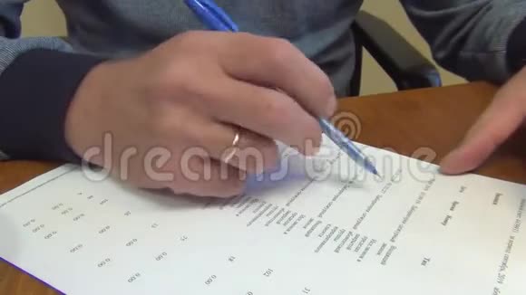一个人用蓝墨水的圆珠笔在白纸上做一些修改特写视频的预览图