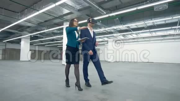 一位戴着VR眼镜的男子正被一位女士的经纪人领着穿过房产视频的预览图