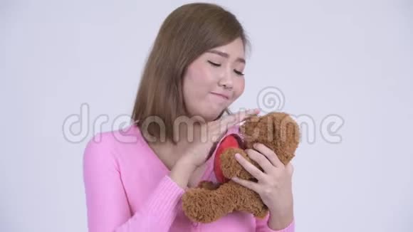 年轻的亚洲女人带着玩具熊表演孩子气视频的预览图