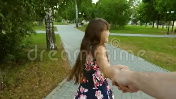 少女穿过夏天的公园笑着牵着爸爸手父母快乐的童年视频的预览图