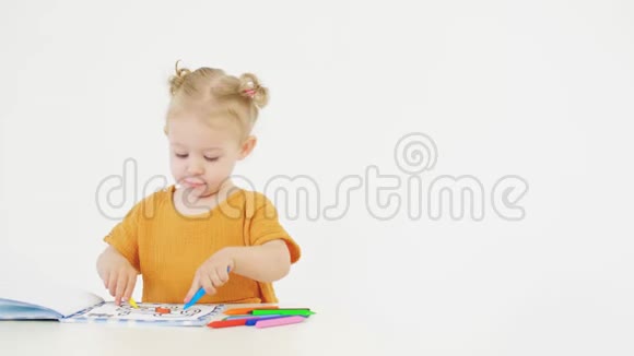 可爱的女婴在白色背景上用蜡笔上色视频的预览图