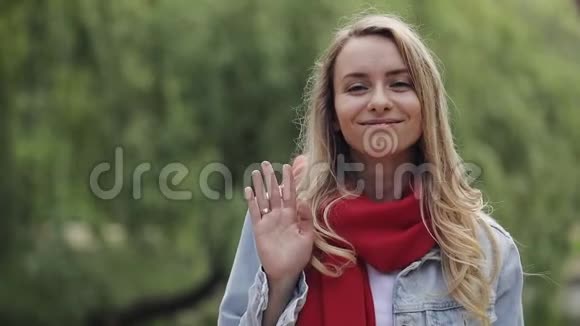 站在公园里戴着红领巾年轻漂亮的女人笑着快乐地享受着积极的生活方式视频的预览图