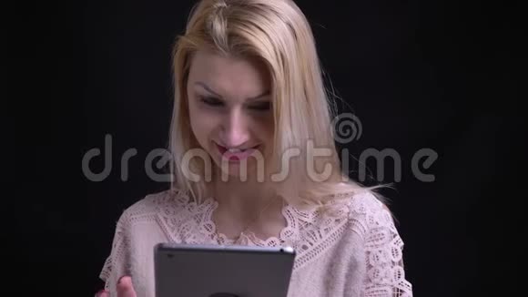 用平板电脑拍摄中年白种人女性的特写镜头然后看着相机微笑视频的预览图