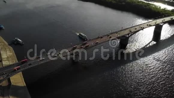 很好的空中镜头一座桥上有汽车和公共汽车船沿着桥下的河走视频的预览图