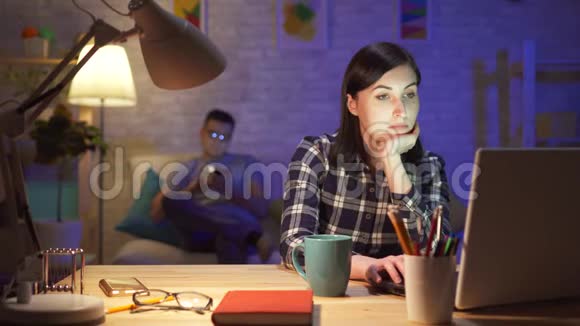 一位年轻女子晚上在一间现代化的公寓里坐在笔记本电脑旁她很想念视频的预览图