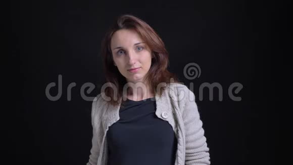 中年黑发白种人妇女的肖像用手指示意在黑色背景上像镜头一样显示视频的预览图