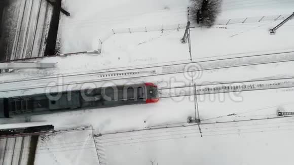 冬季在铁路公路上乘坐灰色列车的空中跟踪拍摄视频的预览图