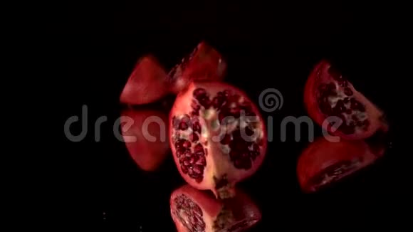 鲜红石榴分成几部分慢动作黑色背景摔成碎片视频的预览图
