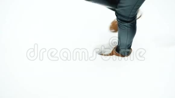 棕色的女性腿在白色的纯雪中留下痕迹视频的预览图