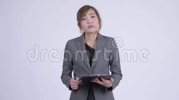 年轻的亚洲女商人边听边写剪贴板视频的预览图