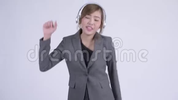 年轻快乐的亚洲女商人听音乐跳舞视频的预览图