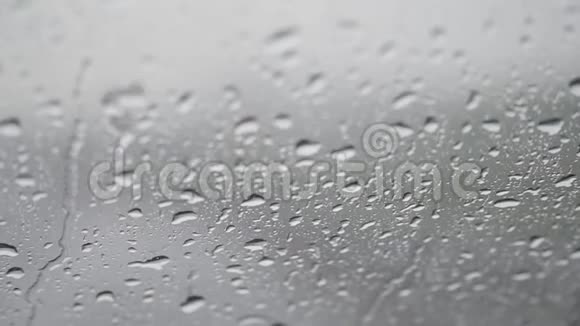 玻璃上的水滴特写雨走开夏季淋浴时大的雨滴撞击窗户玻璃视频的预览图
