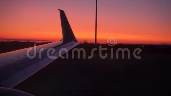 飞机正在准备起飞飞机的机翼在摇晃在夕阳下视频的预览图