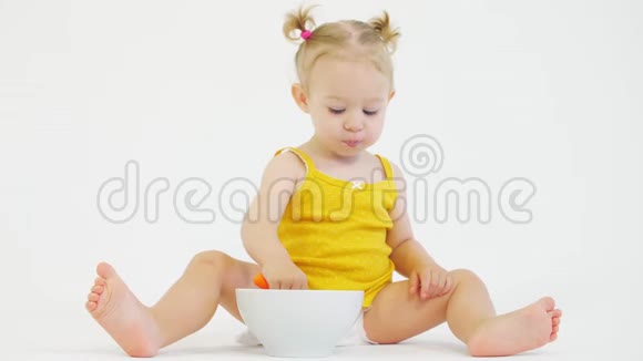 微笑的女婴在白色背景下吃早餐视频的预览图