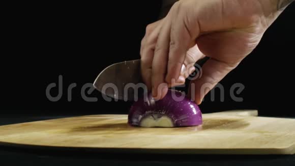 在餐厅的厨房里男人的手紧紧地握着一个紫色的洋葱在木板上股票镜头概念视频的预览图