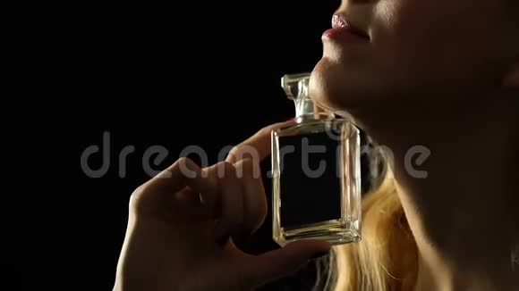 美丽的女人用香水抚摸脖子享受精英香水特写视频的预览图