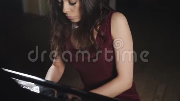 专心致志的女人穿着紫色衣服弹钢琴视频的预览图