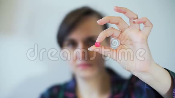 手拿着药丸的女人看着它视频的预览图